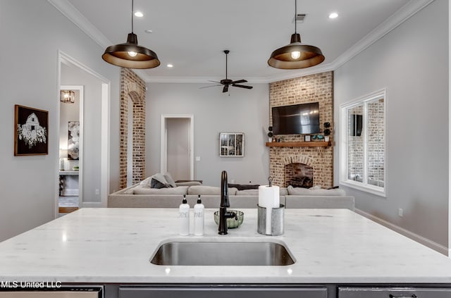 kitchen with an island with sink, decorative light fixtures, and sink