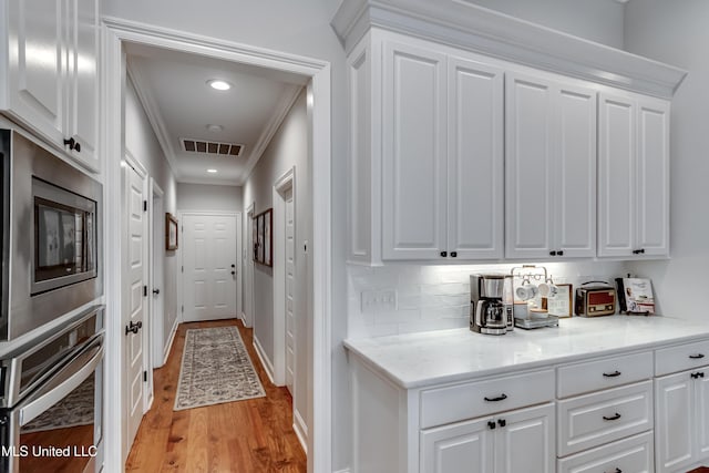 hallway with crown molding and light wood-type flooring