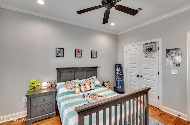 bedroom featuring light hardwood / wood-style flooring, ornamental molding, a closet, and ceiling fan