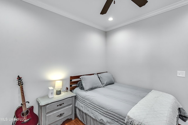 bedroom with crown molding, hardwood / wood-style floors, and ceiling fan