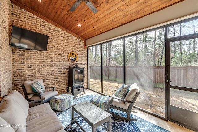 sunroom / solarium with lofted ceiling, plenty of natural light, wooden ceiling, and ceiling fan