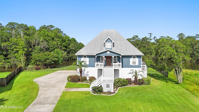 12441 Old Cypress Creek Cv, Diberville, MS 39540 - beach home with stairs, concrete driveway, a porch, and a water view