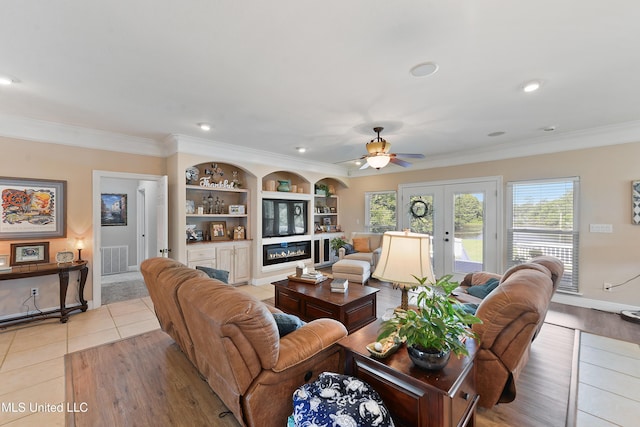 12441 Old Cypress Creek Cv, Diberville, MS 39540 - living area featuring french doors, ceiling fan, ornamental molding, built in shelves, and light wood-type flooring