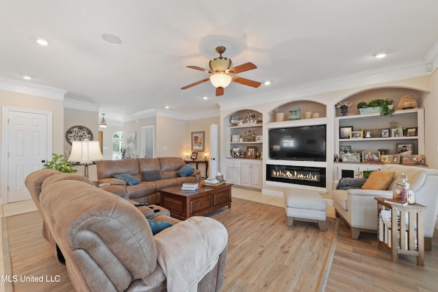 12441 Old Cypress Creek Cv, Diberville, MS 39540 - living room featuring ceiling fan, light wood finished floors, crown molding, a glass covered fireplace, and recessed lighting