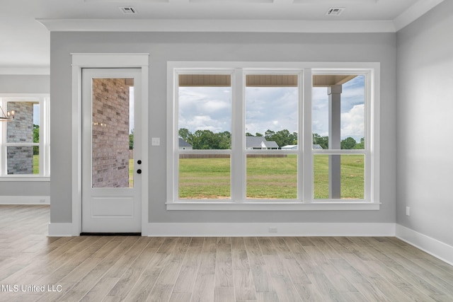 entryway featuring light hardwood / wood-style flooring, crown molding, and a wealth of natural light