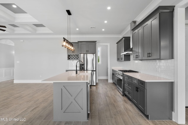 kitchen featuring light wood-type flooring, stainless steel appliances, pendant lighting, gray cabinets, and a center island with sink