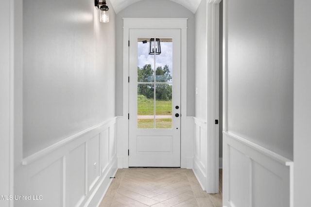 doorway to outside featuring light parquet floors and lofted ceiling