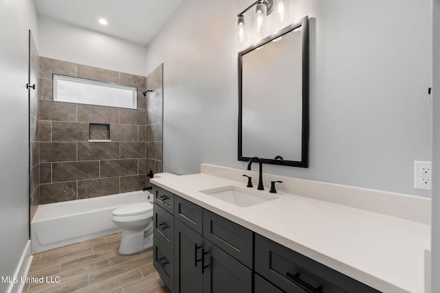 full bathroom with toilet, tiled shower / bath, and vanity