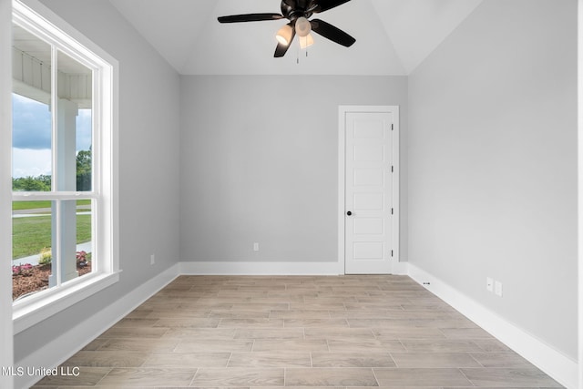 empty room with a wealth of natural light, vaulted ceiling, light hardwood / wood-style floors, and ceiling fan