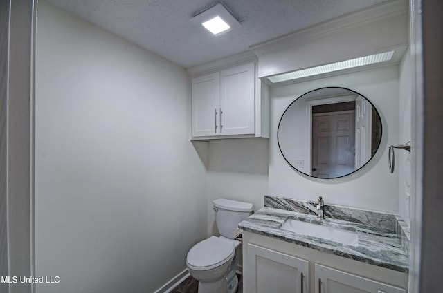 bathroom with vanity, a textured ceiling, and toilet