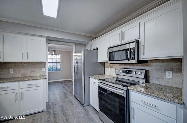 kitchen with light wood-type flooring, stainless steel appliances, white cabinets, crown molding, and decorative backsplash