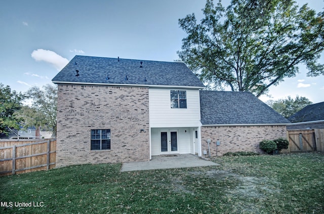 rear view of property featuring a patio area and a lawn