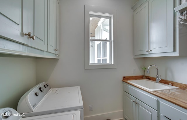 laundry room featuring sink, cabinets, and independent washer and dryer