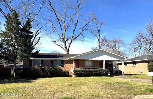 view of front of property with brick siding, a porch, board and batten siding, driveway, and a front lawn