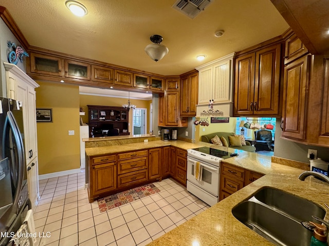 kitchen with black fridge, kitchen peninsula, sink, light tile patterned flooring, and white electric range oven