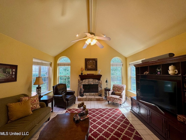 tiled living room with ceiling fan, lofted ceiling with beams, and a stone fireplace