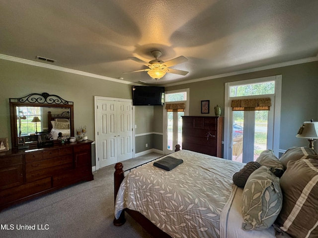 carpeted bedroom with a textured ceiling, crown molding, multiple windows, and ceiling fan