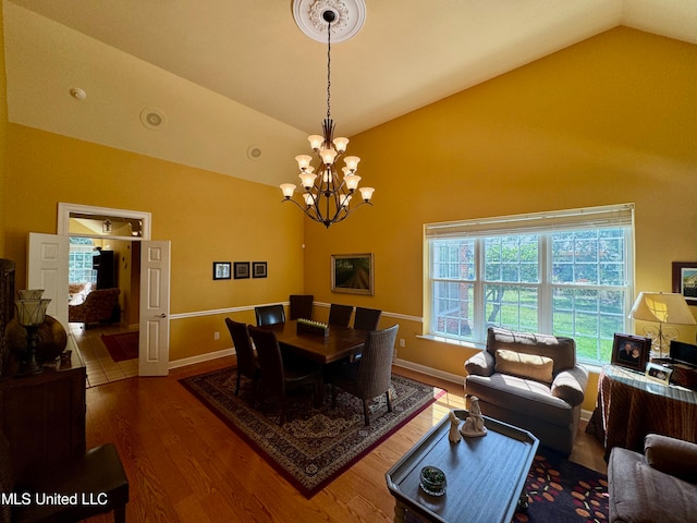 dining room featuring a notable chandelier, dark hardwood / wood-style floors, and vaulted ceiling