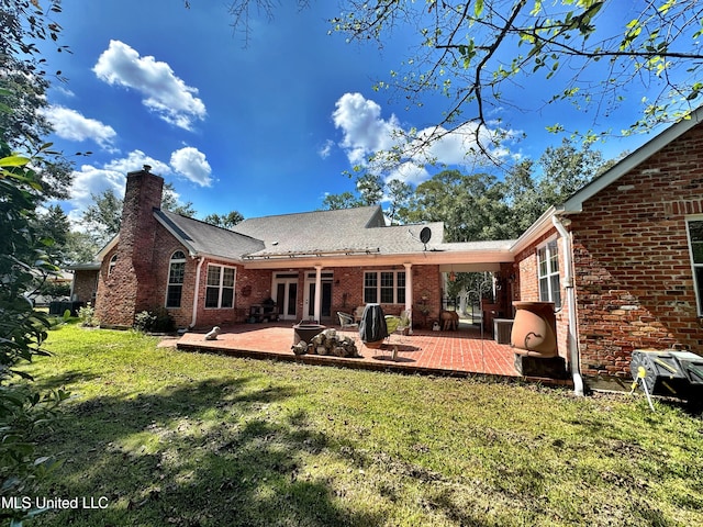 rear view of house featuring a patio area and a lawn