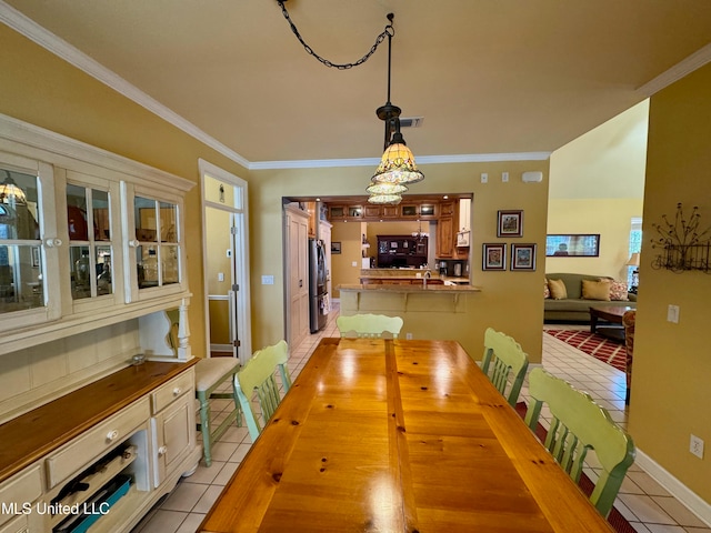 dining room with crown molding and light tile patterned flooring