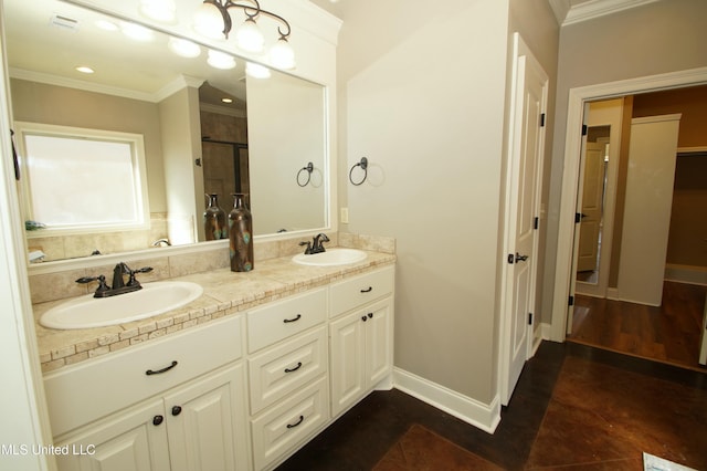 bathroom featuring a sink, ornamental molding, and a shower stall