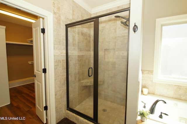 full bath with a stall shower, wood finished floors, crown molding, a bath, and a spacious closet