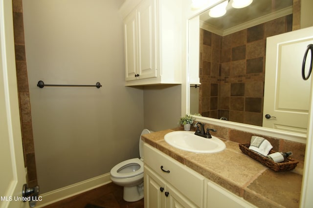 full bath with vanity, crown molding, toilet, and baseboards