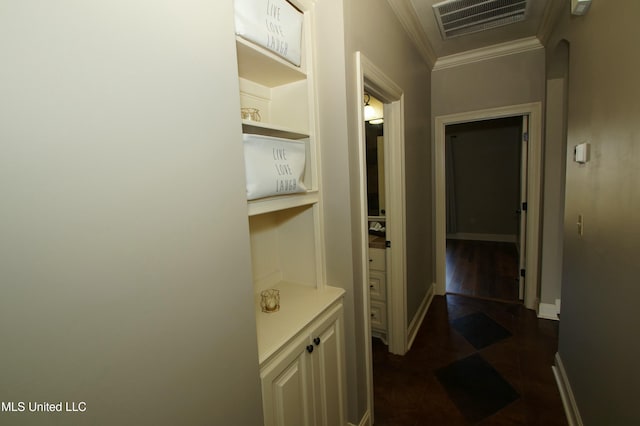 hall featuring arched walkways, baseboards, visible vents, and ornamental molding