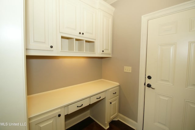 interior space featuring baseboards and built in desk