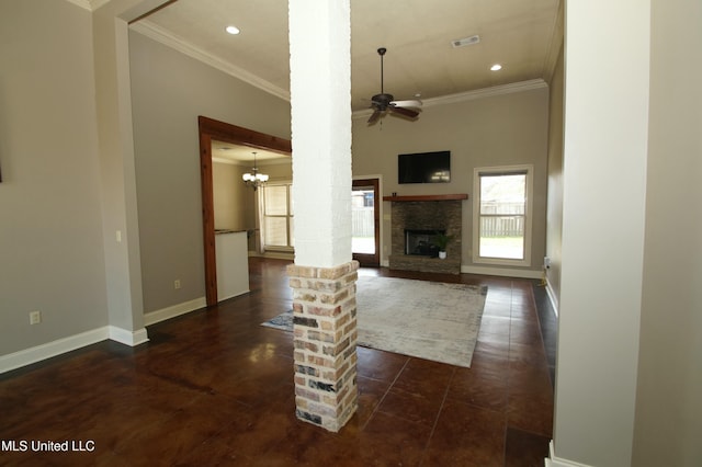 unfurnished living room with visible vents, baseboards, decorative columns, crown molding, and ceiling fan with notable chandelier