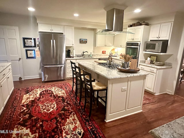 kitchen featuring white cabinets, island range hood, stainless steel appliances, and a center island