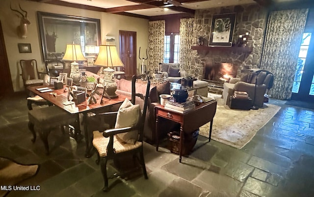 interior space with beam ceiling and a stone fireplace