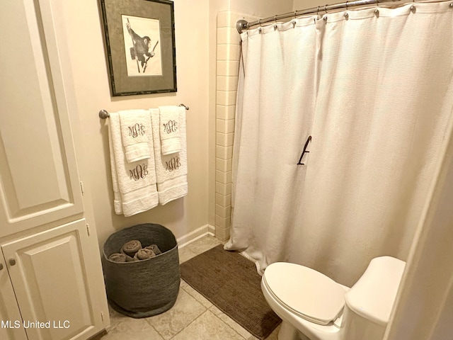 bathroom featuring toilet, tile patterned floors, and a shower with shower curtain