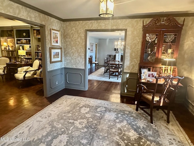 living area with built in shelves, an inviting chandelier, and ornamental molding