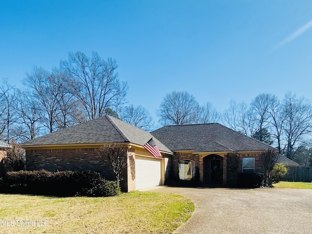 single story home with driveway, a front yard, a shingled roof, a garage, and brick siding