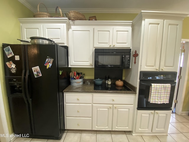 kitchen featuring dark stone countertops, light tile patterned floors, ornamental molding, black appliances, and white cabinets