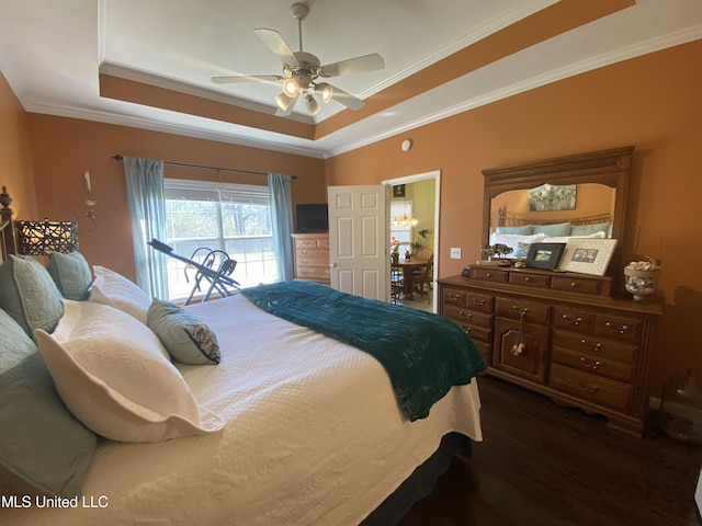 bedroom with a tray ceiling, dark wood-type flooring, ornamental molding, and access to outside