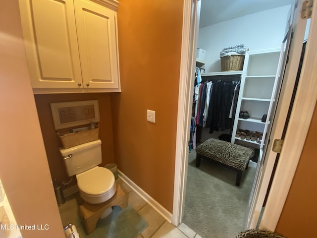 bathroom featuring tile patterned flooring, toilet, and baseboards