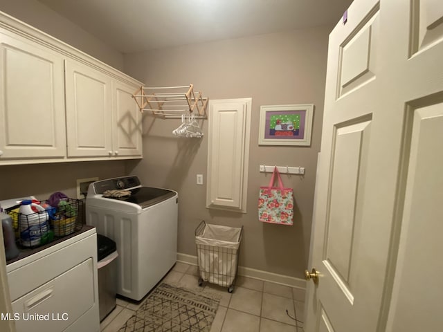 washroom featuring baseboards, cabinet space, separate washer and dryer, and light tile patterned flooring