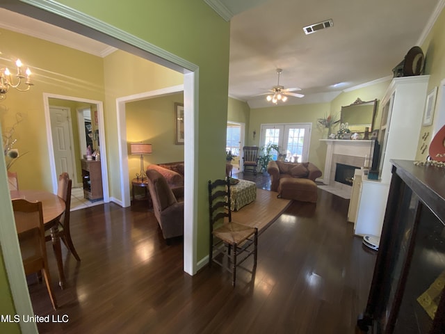 living room with visible vents, crown molding, a fireplace with flush hearth, french doors, and dark wood-style floors