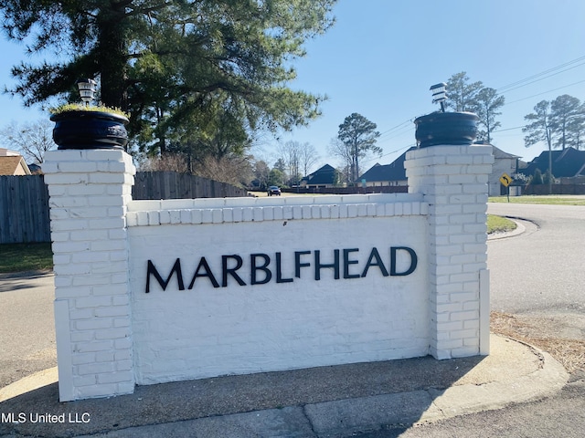 community / neighborhood sign featuring fence