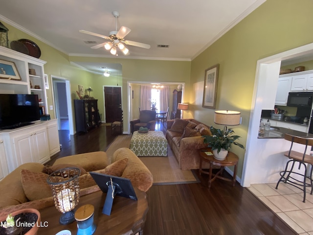 living room featuring visible vents, wood finished floors, ornamental molding, and a ceiling fan