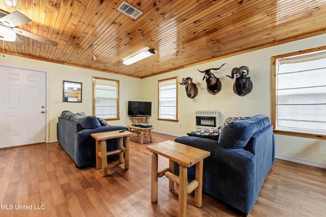 living room featuring wood-type flooring, wooden ceiling, ornamental molding, heating unit, and ceiling fan