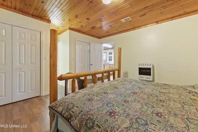 bedroom featuring wood finished floors, heating unit, visible vents, and wood ceiling