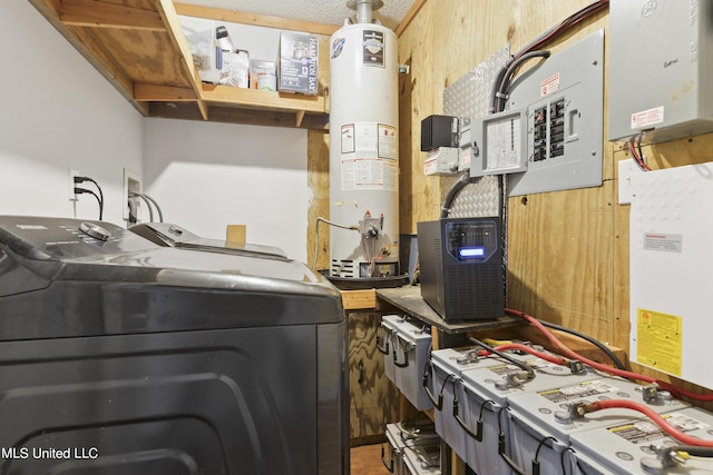 clothes washing area featuring washer and clothes dryer, gas water heater, a workshop area, wood walls, and laundry area