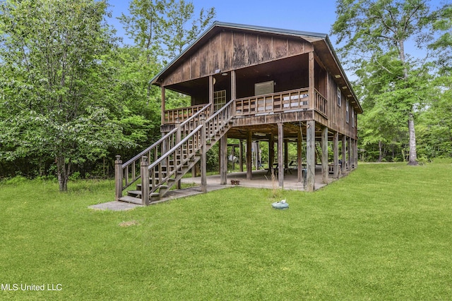 rear view of house featuring a lawn, stairway, and a patio