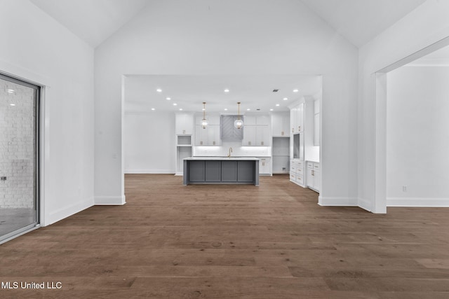 308 Lois Ct, Madison, MS 39110 - unfurnished living room with a sink, dark wood-type flooring, baseboards, high vaulted ceiling, and recessed lighting