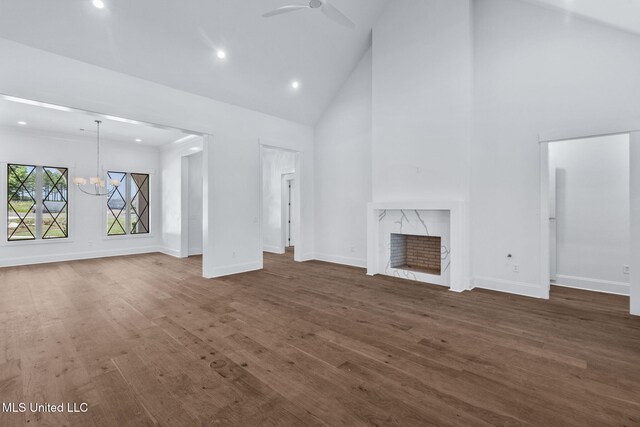 308 Lois Ct, Madison, MS 39110 - unfurnished living room featuring high vaulted ceiling, a chandelier, baseboards, wood finished floors, and a fireplace