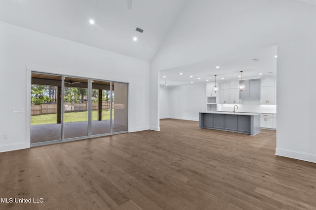 308 Lois Ct, Madison, MS 39110 - unfurnished living room with a sink, baseboards, recessed lighting, wood finished floors, and high vaulted ceiling