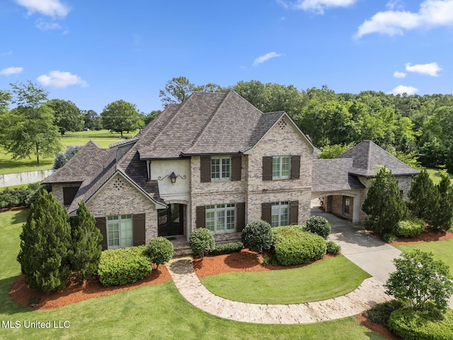 430 Johnstone Dr, Madison, MS 39110 - french country home featuring a front yard, brick siding, driveway, and a shingled roof